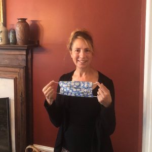 cincinnati parks volunteer melinda holding up a blue mask she made for staff